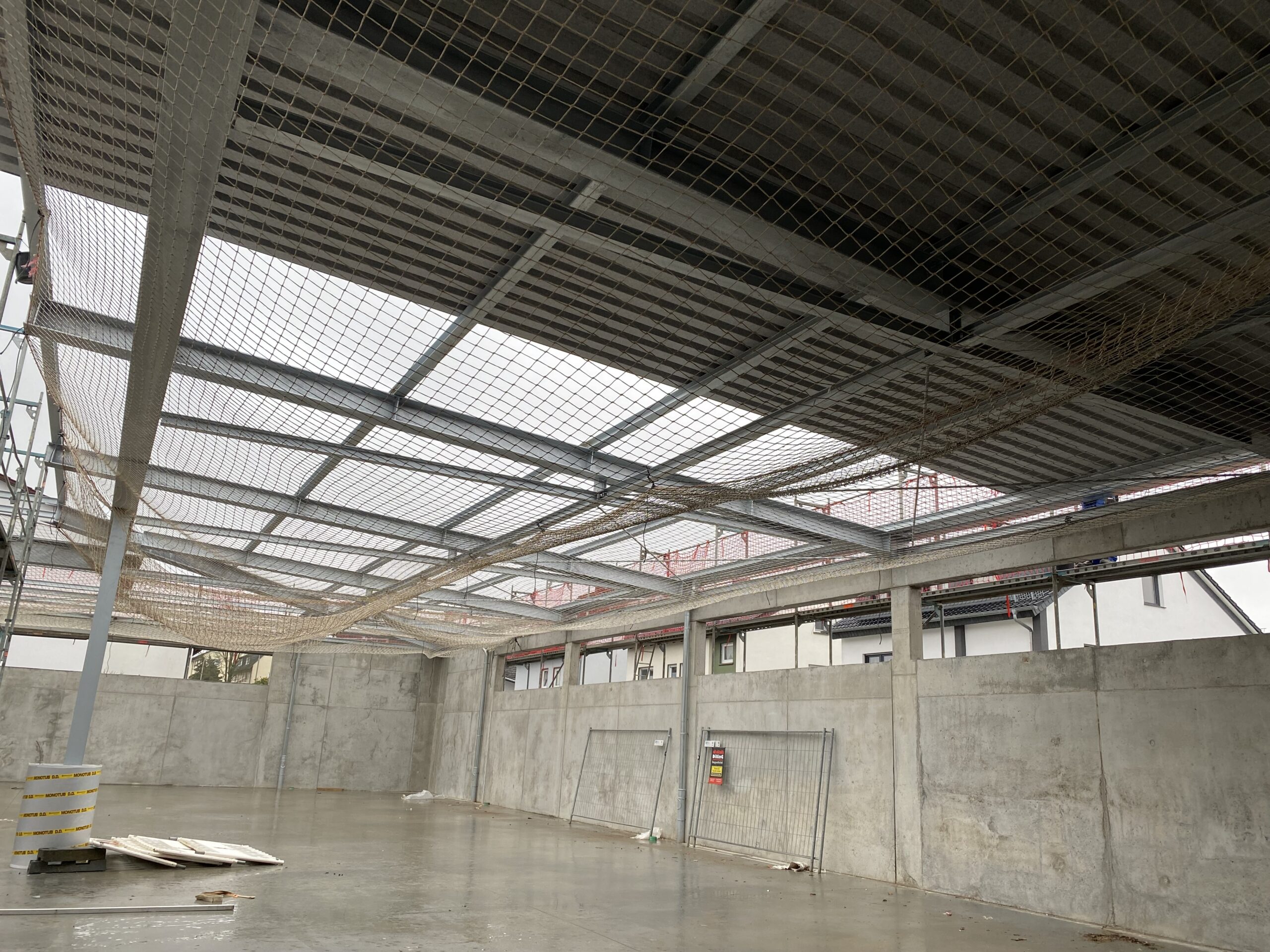 Industriehalle im Bau mit Tragwerk, Netzsicherung und technischer Rohbauphase